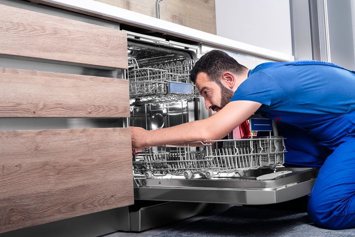 Tecnico ripara una lavastoviglie in cucina