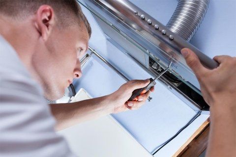 Tecnico che ripara una cappa aspirante
